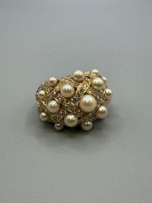 pearl and gold ring with diamonds on a gray surface