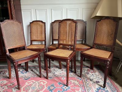 four wooden chairs with cane back and cane backs sit on a rug