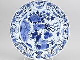blue and white plate with flowers and birds on it