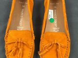 an image of a pair of orange shoes with tassels on them