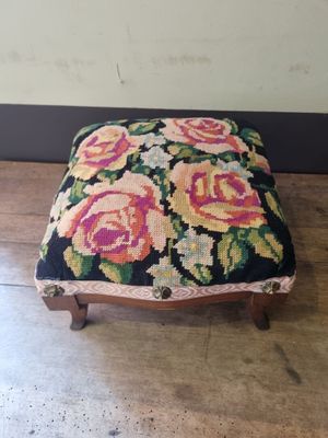 a small foot stool with a floral design on it