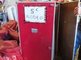 a man standing next to a red refrigerator in a garage