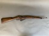 an old rifle is laying on a white sheet on a table