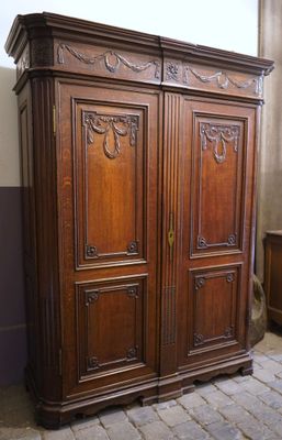 a large wooden armoire in the corner of a room