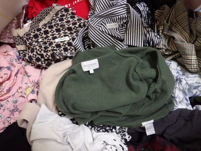 a pile of clothes sitting on top of a black suitcase