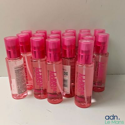 several bottles of pink liquid are lined up on a white surface