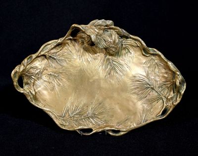 une assiette en or ornée d'un oiseau sur fond noir