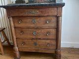 a small chest of drawers with a lamp on top of it