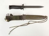 un couteau et son étui posés sur une surface blanche