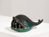 une petite sculpture représentant une baleine posée sur un socle blanc
