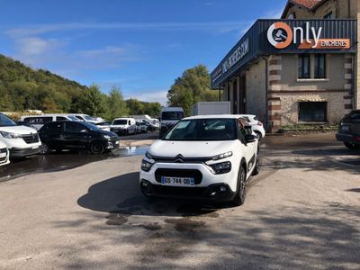une voiture blanche garée devant un bâtiment dans un parking