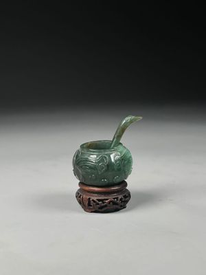 an image of a green vase sitting on top of a wooden stand