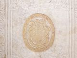 a white tile with a gold medallion on it