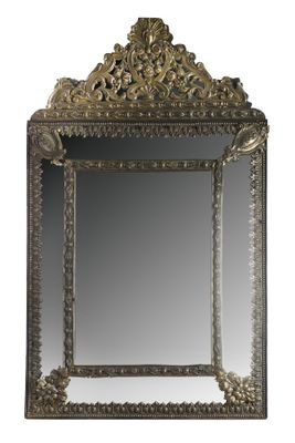un miroir sculpté avec un cadre doré sur fond blanc