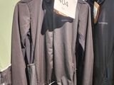 trois vestes suspendues à un portant dans un magasin, avec leurs étiquettes de prix