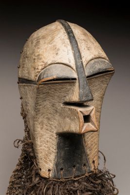 un gros plan d'un masque en bois orné d'une étoile