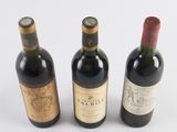three bottles of wine are lined up on a white surface