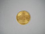 a close up of a gold coin on a white surface