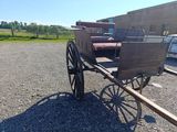 a horse and buggy that is sitting in the gravel