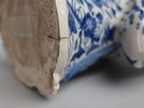 a close up of a blue and white vase with a spider on it