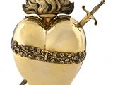 an image of a golden heart shaped box with a sword sticking out of it
