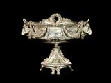 a silver bowl with horses on it on a black background