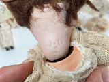 a person holding a doll with a doll in it ' s hand
