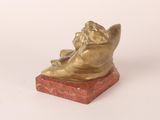 statue of a woman sitting on a red marble base with a white background