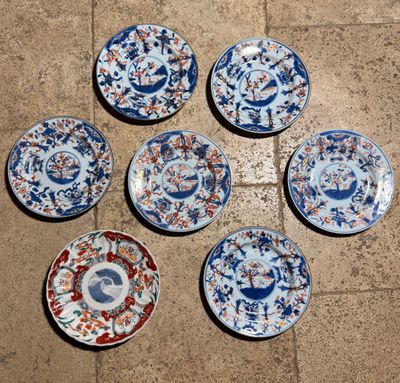 six assiettes bleues et blanches sont disposées en cercle sur un sol carrelé