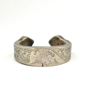 un gros plan sur un bracelet en argent orné d'un motif