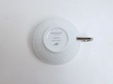 a white plate with a silver handle on a white table