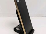 a close up of a cell phone on a stand on a white surface
