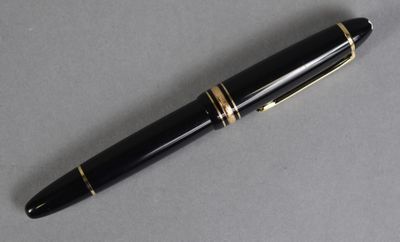 an image of a pen with a gold trim on a gray surface