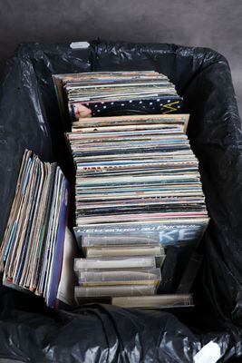 un sac noir rempli de disques vinyles posé par terre