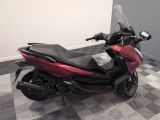 a red motorcycle parked in a room with a checkered floor