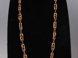 a gold chain necklace on a mannequin display