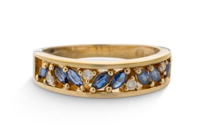 gros plan d'une bague en or avec saphirs bleus et diamants
