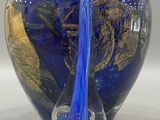 a blue glass vase with a gold leaf design on it
