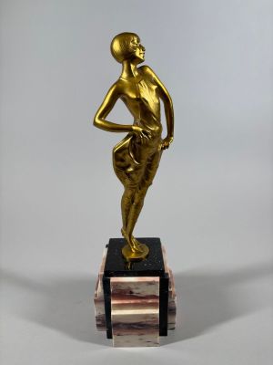 bronze statue of a woman holding a ball on a marble base