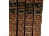 three old books sitting on top of each other on a white surface