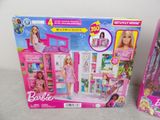two barbie dolls are sitting on a table next to each other