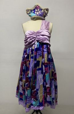 une robe posée sur un présentoir à mannequin, surmontée d'un chapeau