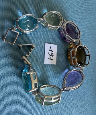 un bracelet en verre et en métal, orné d'une plaque