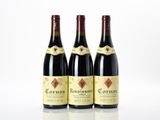 three bottles of red wine sitting on top of a table