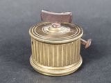 a small brass box with a wooden handle on a table
