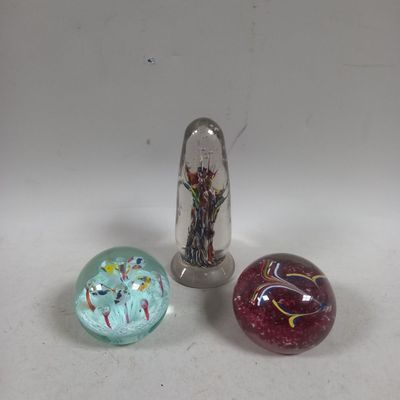 trois billes de verre posées les unes à côté des autres sur une table