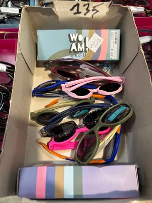 many pairs of sunglasses in a box on a table