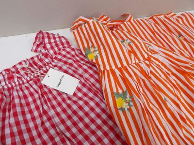 two red and white gingham dresses on display in a box