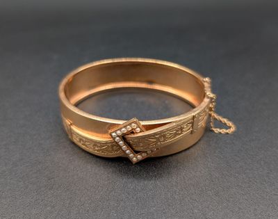 un gros plan d'une bague en or entourée d'une chaîne