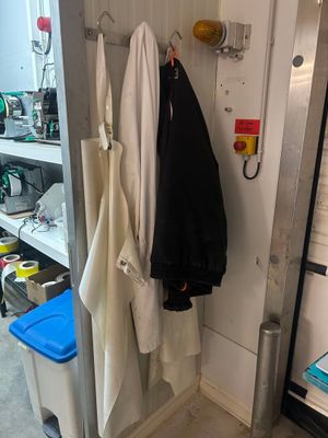 deux manteaux suspendus à un porte-manteau dans une petite pièce
